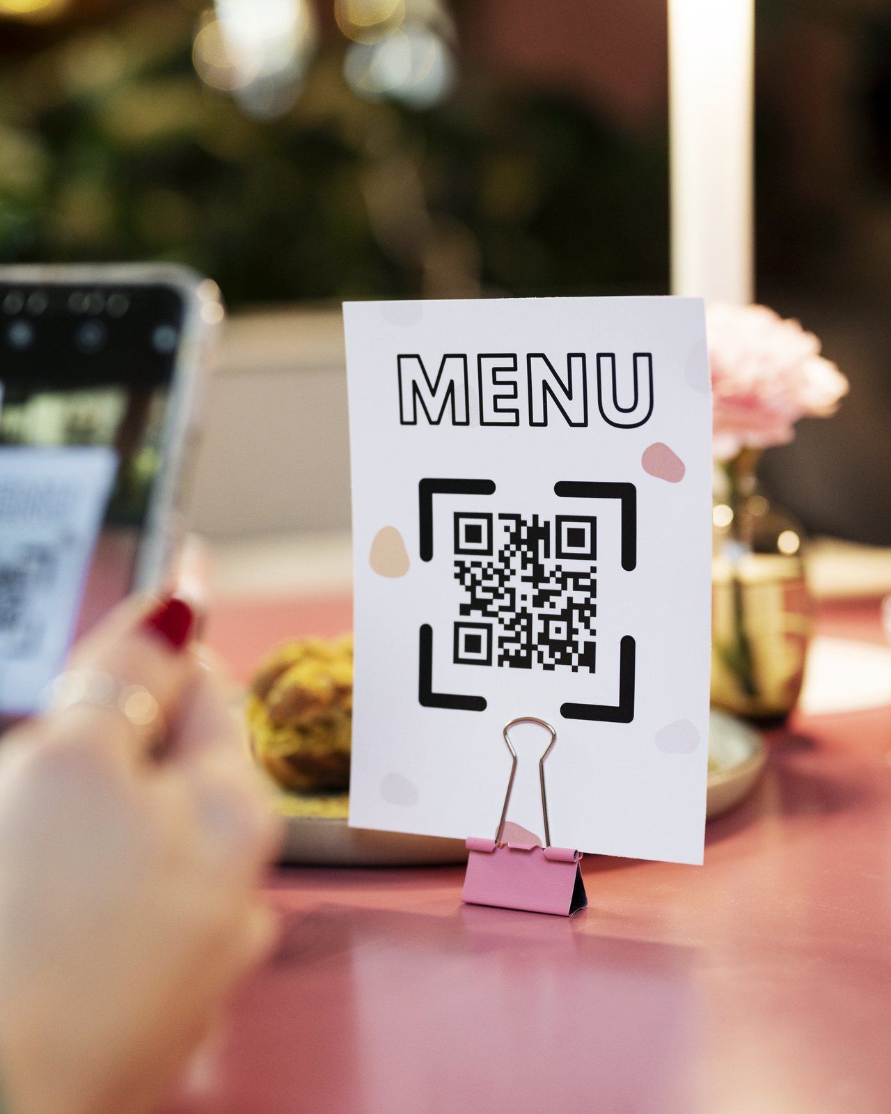 A café table QR code menu being scanned with a phone